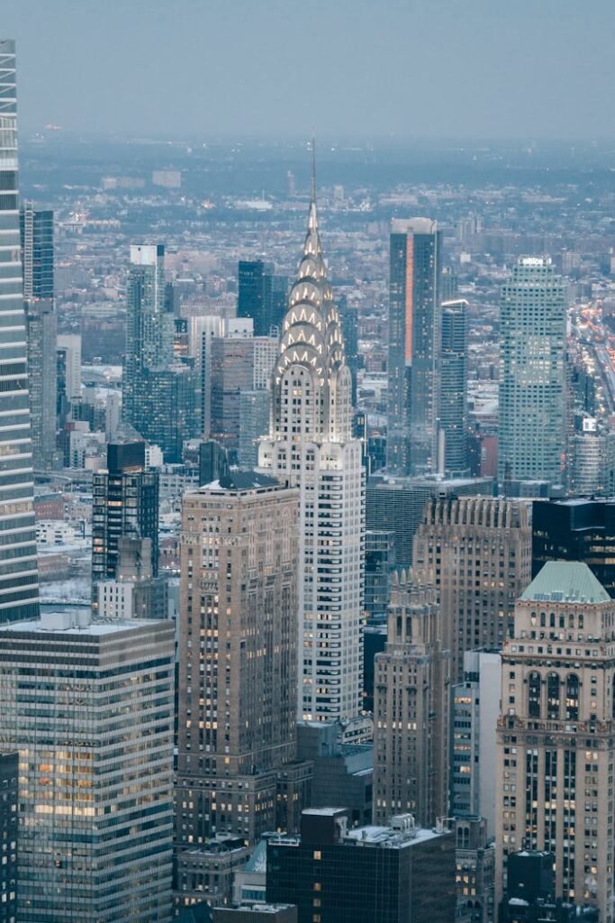 Modern skyscrapers located on streets in financial district against cloudless sky and residential houses in contemporary megapolis against cloudless sky