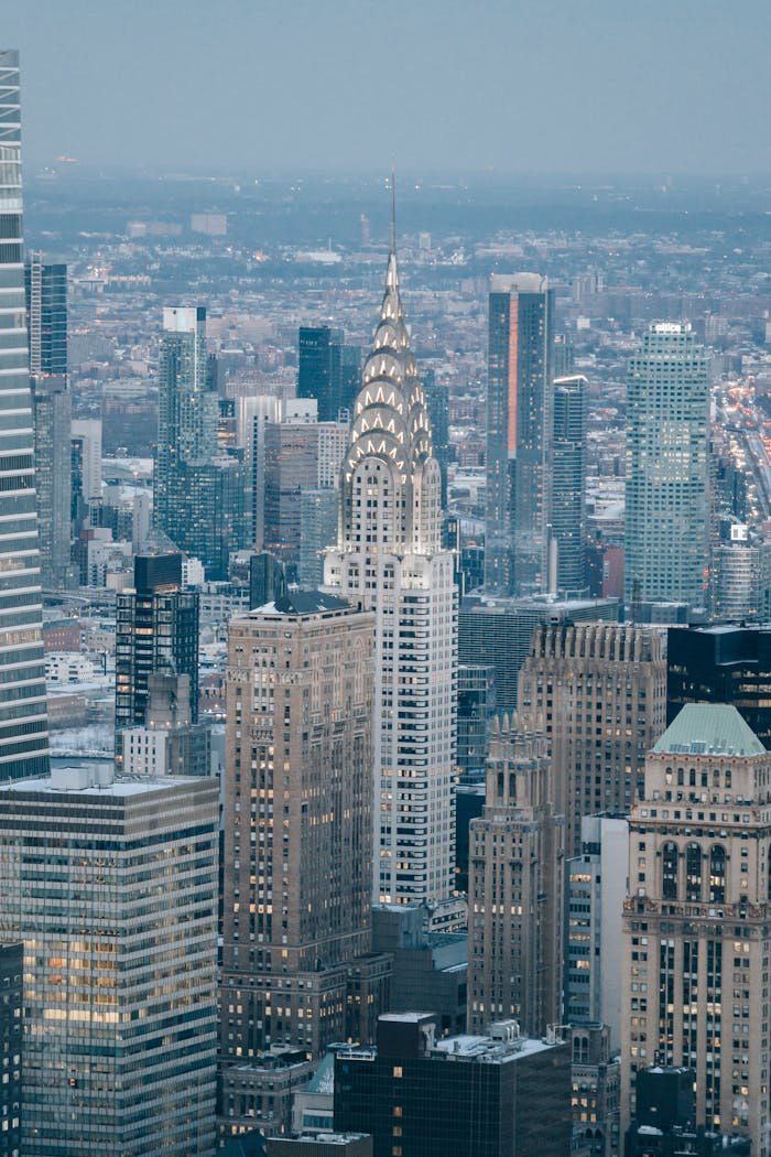 Modern skyscrapers located on streets in financial district against cloudless sky and residential houses in contemporary megapolis against cloudless sky